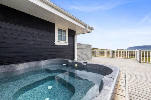 a swimming pool on a deck next to a house at Venture Vacations-Golden Circle Hot Tub Cabin in Selfoss