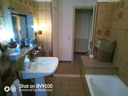 La salle de bains est pourvue d'un lavabo, d'une baignoire et d'un miroir. dans l'établissement Antico Casolare da Francesca, à Porto Viro