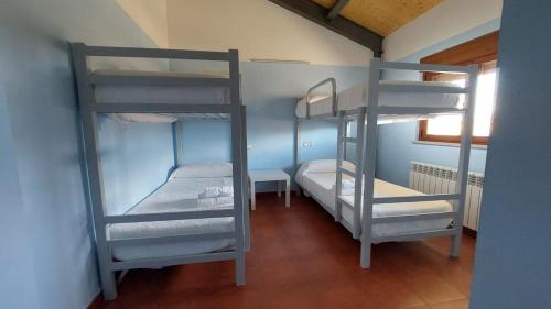 a room with three bunk beds in a room at Albergue Villa de Salvatierra in Salvatierra de Tormes