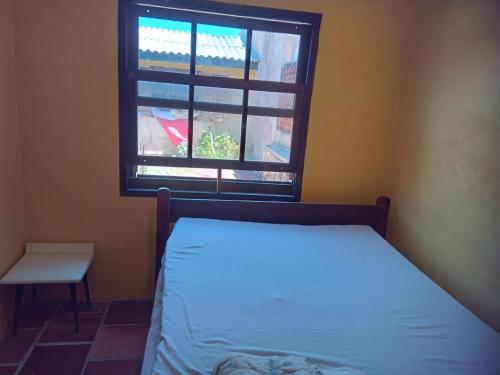 1 dormitorio con cama y ventana en Aluguel da Léo, en Cidreira