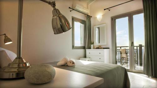 a bedroom with a bed with a table and a lamp at Mani Apartments Suites in Agios Nikolaos