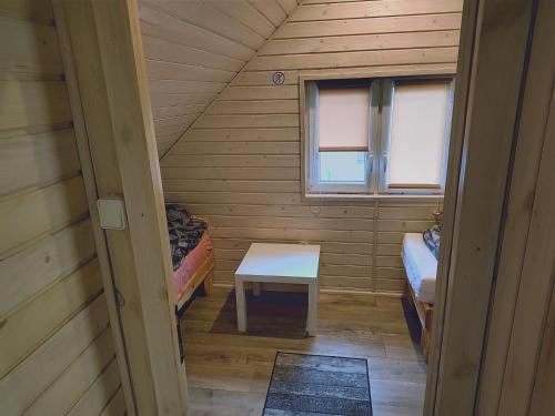 Kleines Zimmer mit 2 Betten und einem Tisch in der Unterkunft Domki Przydwórz 