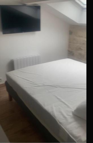 Cette chambre comprend un lit blanc. dans l'établissement HOME BRUNO, à Triel-sur-Seine