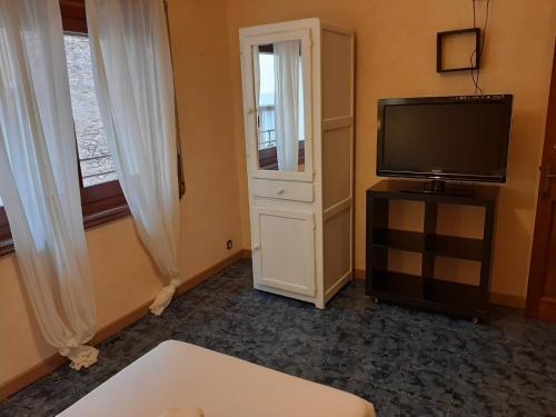 a living room with a flat screen tv and a dresser at Hotel Rosa & Spa Begur in Begur