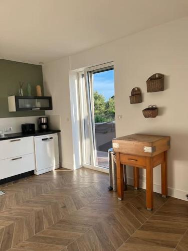 Cette chambre comprend une cuisine avec une table et une fenêtre. dans l'établissement La Maison de Kertouez - La Foret, à La Forêt-Fouesnant