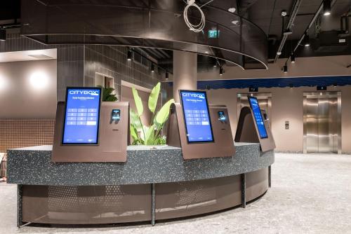 a display with three screens on a counter in a room at Citybox Helsinki in Helsinki