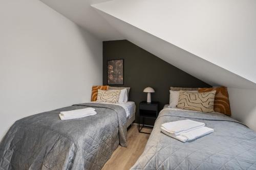 a attic room with two beds and a staircase at Venture Vacations - Best Possible Location-Laugavegur Luxury Loft in Reykjavík