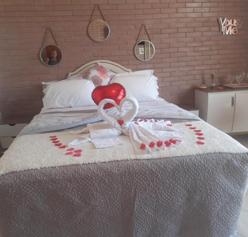 a bed with a heart and a balloon on it at Pousada Estância da Pinha in Santo Antônio do Pinhal