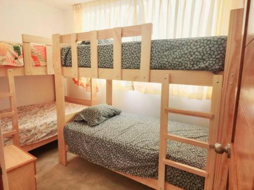 - une chambre avec 2 lits superposés et un banc dans l'établissement Casa del Norte: Casa del Norte: Mediterranean Charm in Lobitos, Peru - Ideal Surf Haven for All Levels, à Lobitos