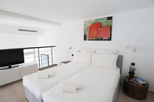 a white bedroom with a large bed and a tv at Diodato Luxury Residence Corbusier Promenade & Sea View with Pool #3 in Roquebrune-Cap-Martin