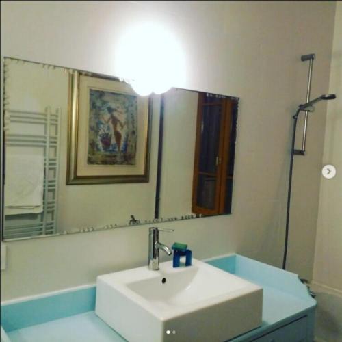 uma casa de banho com um lavatório branco e um espelho. em La Maison Pain d'Epices em Chichilianne