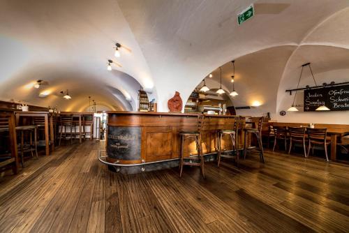 um restaurante com um bar com mesas e cadeiras em Rathauskeller Melk em Melk