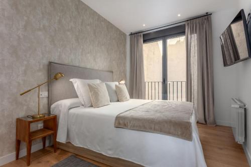 1 dormitorio con cama blanca y ventana en Centric Puerta del sol and Canalejas III, en Madrid