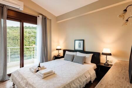 1 dormitorio con cama y ventana grande en Villa Armonia - Beachfront Majestic Retreat, en Petalidi