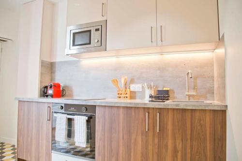 une cuisine avec une cuisinière et un micro-ondes dans l'établissement Trendy familly apt in Mouffetard, à Paris
