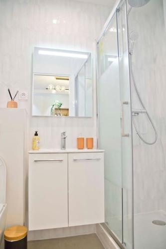 une salle de bain blanche avec une douche et un lavabo dans l'établissement Trendy familly apt in Mouffetard, à Paris