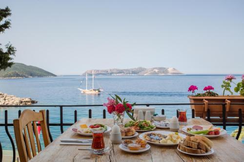 a table with food and a view of the ocean at Aqua Princess Hotel in Kaş
