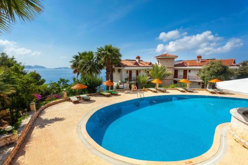 a swimming pool in front of a villa at Aquarius Hotel in Kaş