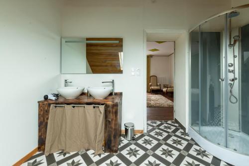 Un baño con dos lavabos y una ducha. en La Maison Qui Ronronne, en Riec-sur-Bélon