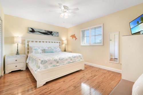 a bedroom with a bed and a ceiling fan at Funshine Pointe Capri in St. Pete Beach