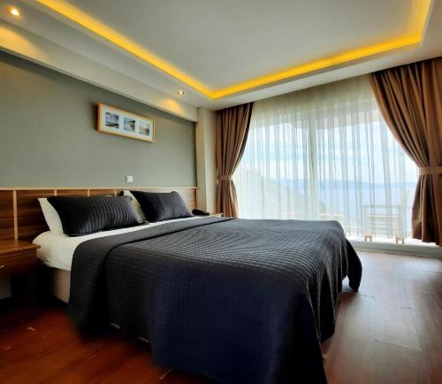 a bedroom with a bed and a large window at Aquarius Hotel in Kas