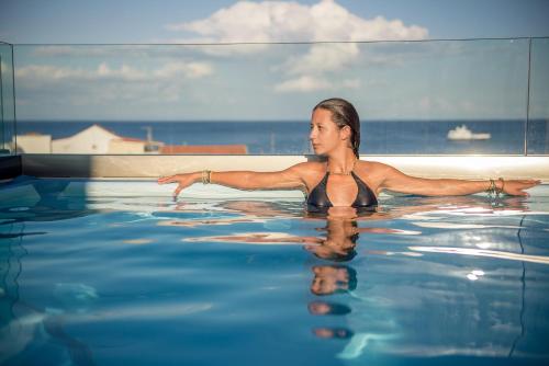 a woman is in a swimming pool at Diana Hotel in Zakynthos Town