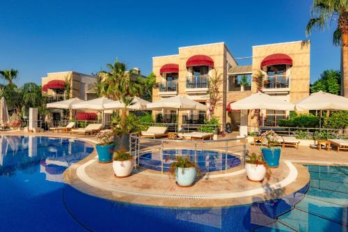 un complejo con una piscina con mesas y sombrillas en Bodrium Hotel & Spa en Bodrum