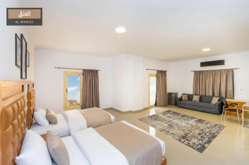a hotel room with two beds and a couch at Al Manzel Sheikh Zayed in 6th Of October