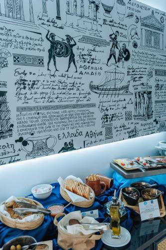 Una mesa cubierta con platos de comida junto a una pared. en Meandros Boutique & Spa Hotel - Adults Only, en Kalamaki