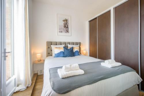 une chambre avec un grand lit avec des serviettes dessus dans l'établissement Cocon des Minimes - Appt pour 3 avec balcon, à Toulouse