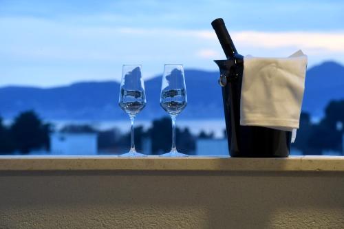 two wine glasses and a bottle on a ledge at K&P - Zadar Luxurious Retreat - BRAND NEW !! in Zadar