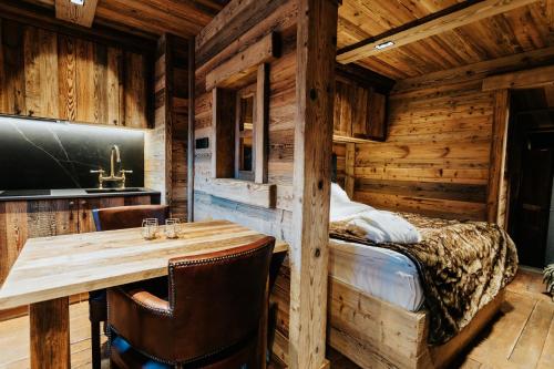 a dining room with a table and a bed at Chalet Cime Bianche in Breuil-Cervinia