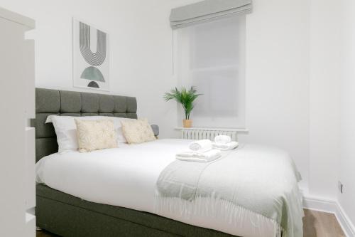 Una cama blanca con dos toallas encima. en Luxury Apartments - Fitzrovia en Londres