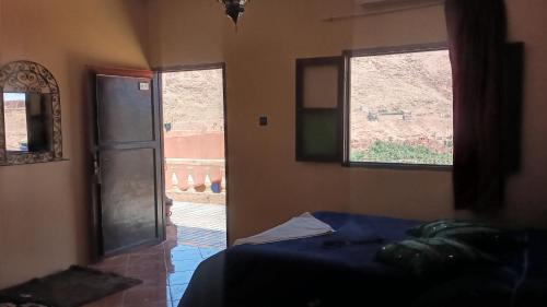 a bedroom with a bed and a window and a door at Auberge ALI Todra A Natural Oasis in Tinerhir