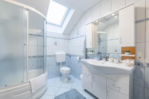 uma casa de banho com um lavatório, um chuveiro e um WC. em Apartment Eli em Kranjska Gora