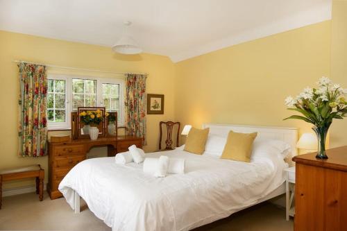 a bedroom with a white bed and a dresser and a window at Woodcutter's Cottage - Peaceful Country Retreat! 