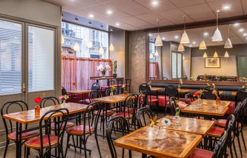 un restaurant avec des tables en bois et des chaises rouges dans l'établissement Grand Hôtel De Turin, à Paris