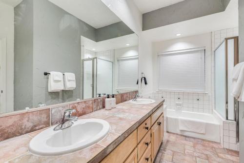 新布朗費爾斯的住宿－Comal Condo - Riverfont Complex Across from Schlitterbahn，浴室配有2个盥洗盆和1个浴缸。