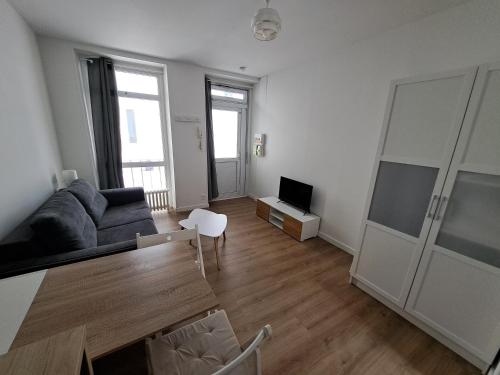 un salon avec un canapé et une table dans l'établissement Appartement Vichy Centre-ville Proche Cure Thermale, à Vichy
