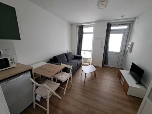 un salon avec un canapé et une table dans l'établissement Appartement Vichy Centre-ville Proche Cure Thermale, à Vichy
