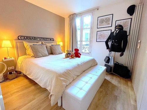 - une chambre avec deux ours en peluche assis sur un lit dans l'établissement L'appartement Vavin, à Paris