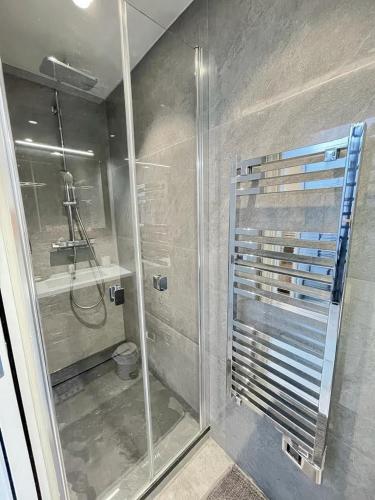 une douche avec une porte vitrée dans une salle de bain dans l'établissement Beach front, Superbe appartement pour 4 personnes, à Nice