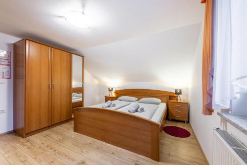 Apartment Eli في كراجسكا غورا: غرفة نوم بسرير وخزانة خشبية