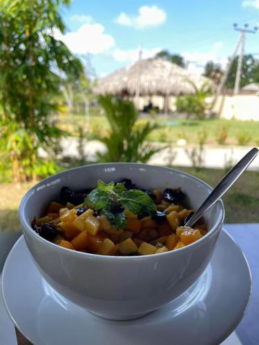 een kom eten op een witte plaat bij Paddyway Resort in Arugam Bay