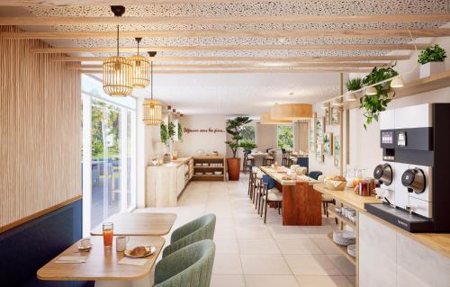 una cucina e una sala da pranzo con tavoli e sedie di Résidence Prestige Odalys Le Riviera a Hyères