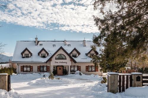 a house covered in snow in front at Dom Malowany in Wetlina