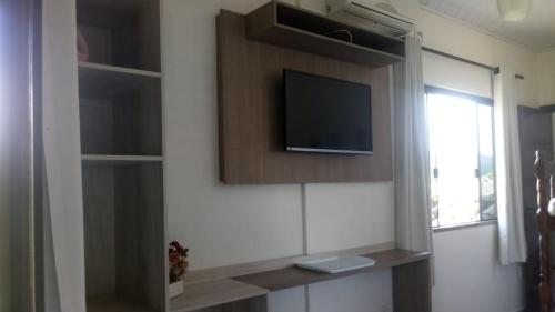 a living room with a tv on a wall at Pousada Estrela da Manhã in Penha