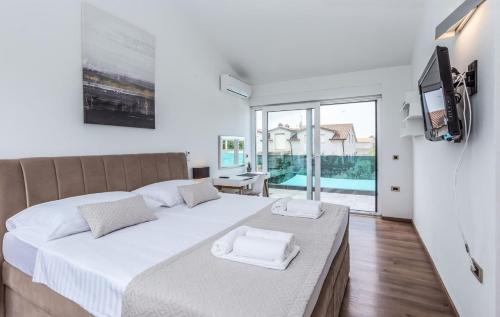 een slaapkamer met een groot bed en een groot raam bij Modern villa zara with pool in Visnjan in Radoši kod Višnjana