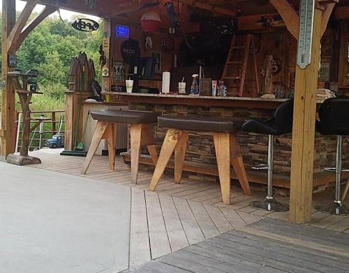 a bar with wooden tables and chairs in a building at Happy Bottom Riverfront Cabin, Petersburg,WV in Rig