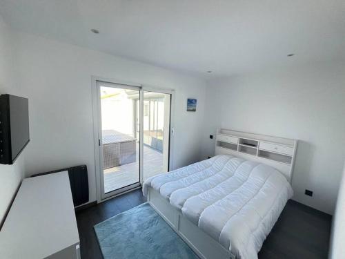 une chambre blanche avec un lit et une fenêtre dans l'établissement Villa avec piscine, à Saint-Jean-de-Monts